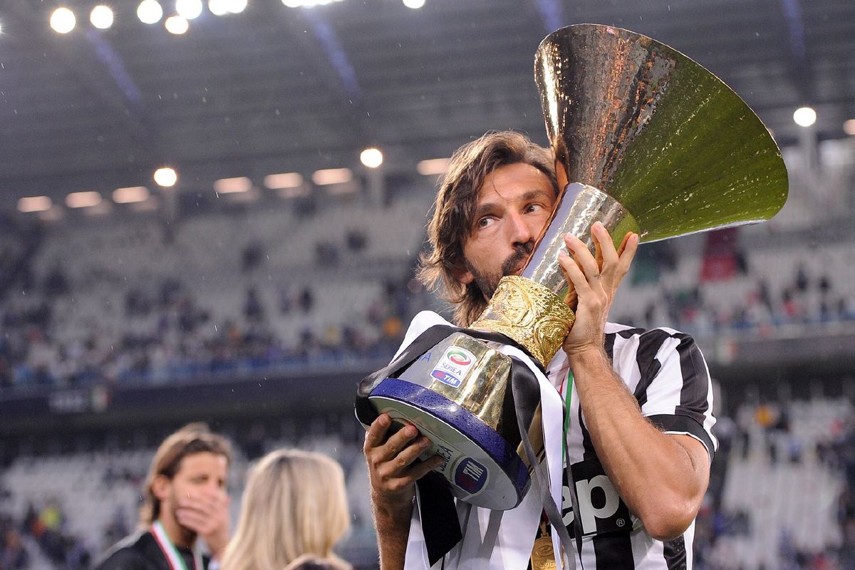 皮尔洛高举世界杯奖杯庆祝胜利，脸上洋溢着胜利的喜悦