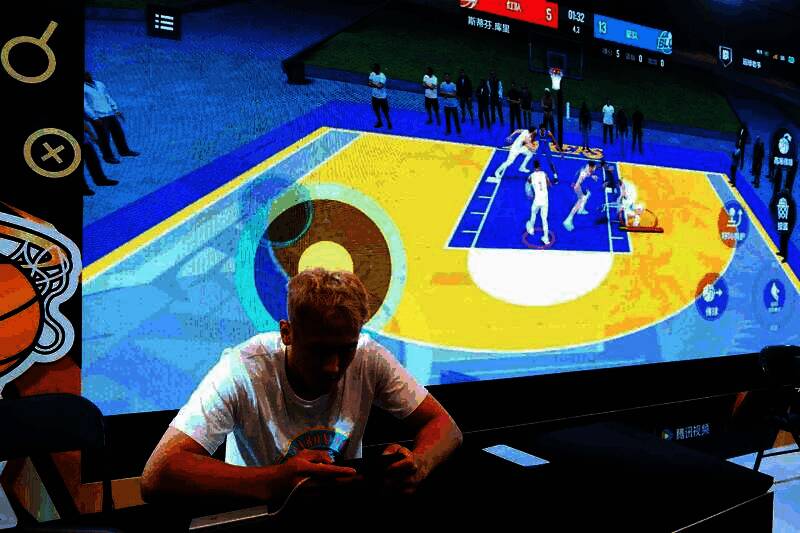 多位网红与嘉宾在NBA2K手游展台前合影，手持游戏道具，笑容灿烂