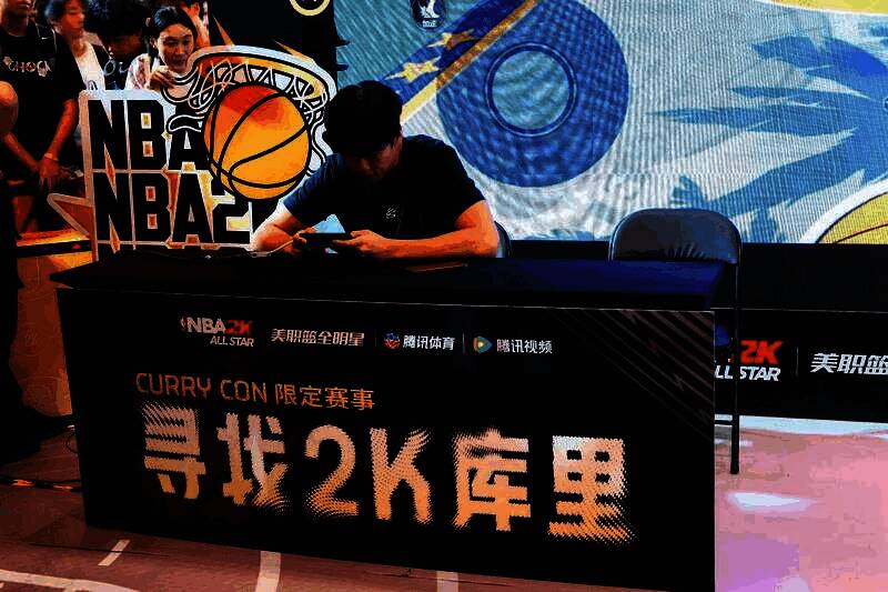 现场大屏幕播放游戏精彩集锦，观众围坐观看，气氛热烈