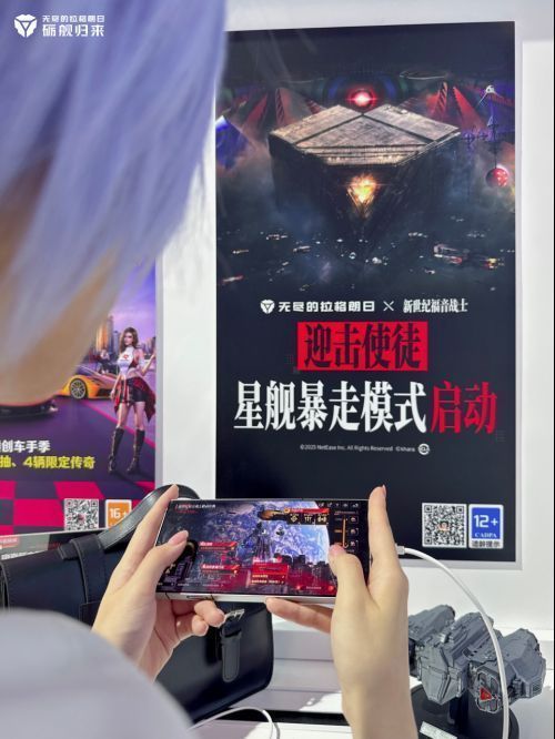 coser扮演的绫波丽身穿蓝白校服，端坐在游戏设备前专注操作，背景为无尽的拉格朗日主题展台