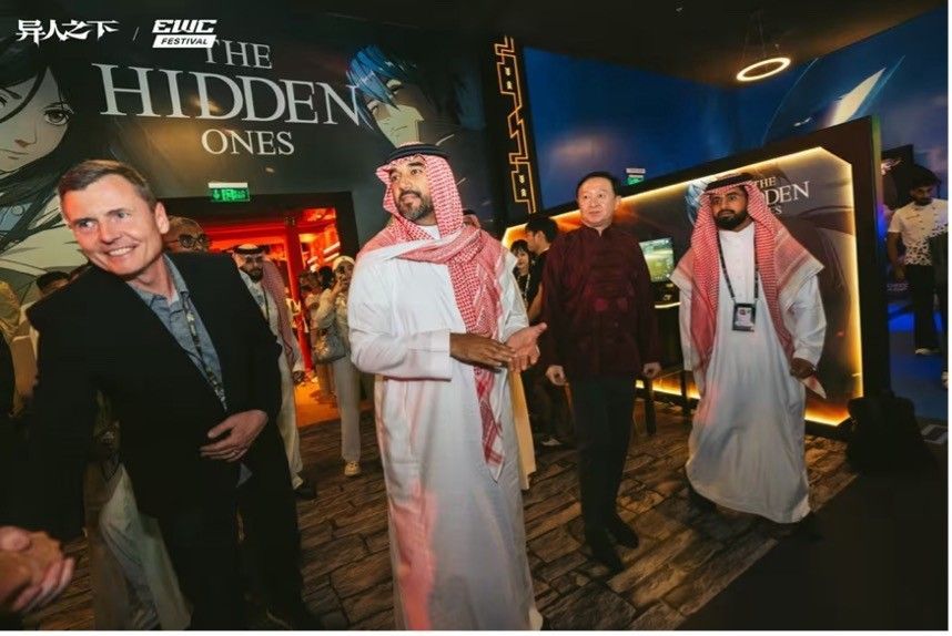 中国驻沙特大使与《异人之下》开发团队合影，背景为展台中式风格装饰