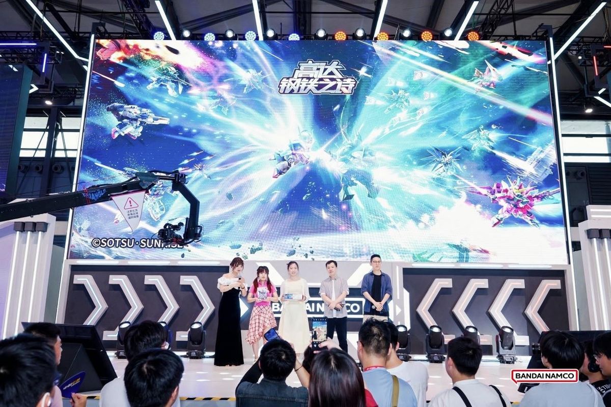 《高达钢铁之诗》展台，屏幕上播放新版本宣传视频，玩家围观讨论