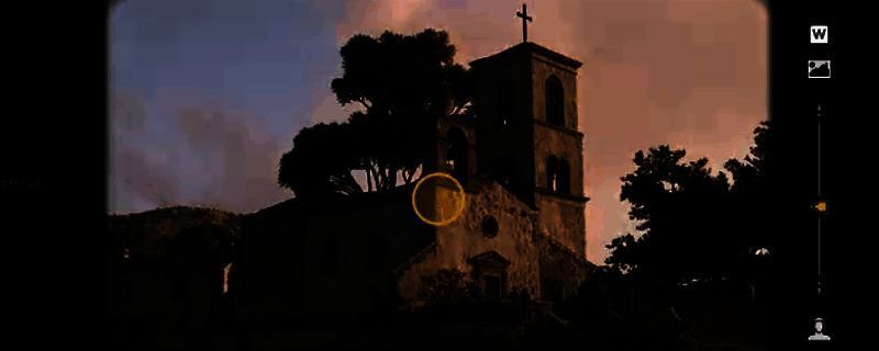 《四海兄弟：故乡》序章矿洞内部场景，昏暗灯光下角色手持提灯探索，地面散落工具与旧物，首个收集品放置于石堆旁