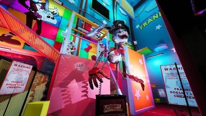 游戏内场景俯视视角，迷宫般的走廊布满血迹与涂鸦，红色应急灯闪烁不定