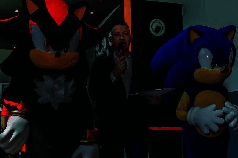 亚洲航空刺猬索尼克主题飞机停靠在跑道上，机身绘有蓝色刺猬索尼克奔跑形象，背景为晴朗天空