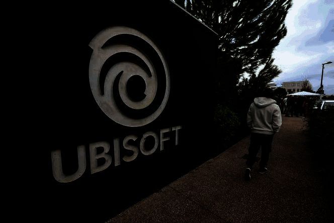 育碧巴黎总部外员工举牌抗议现场，人群手持标语，气氛严肃