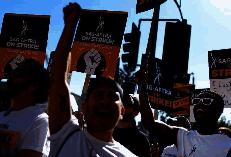 工会代表在新闻发布会上宣读声明，背景屏幕显示‘保护表演者免受AI滥用’字样