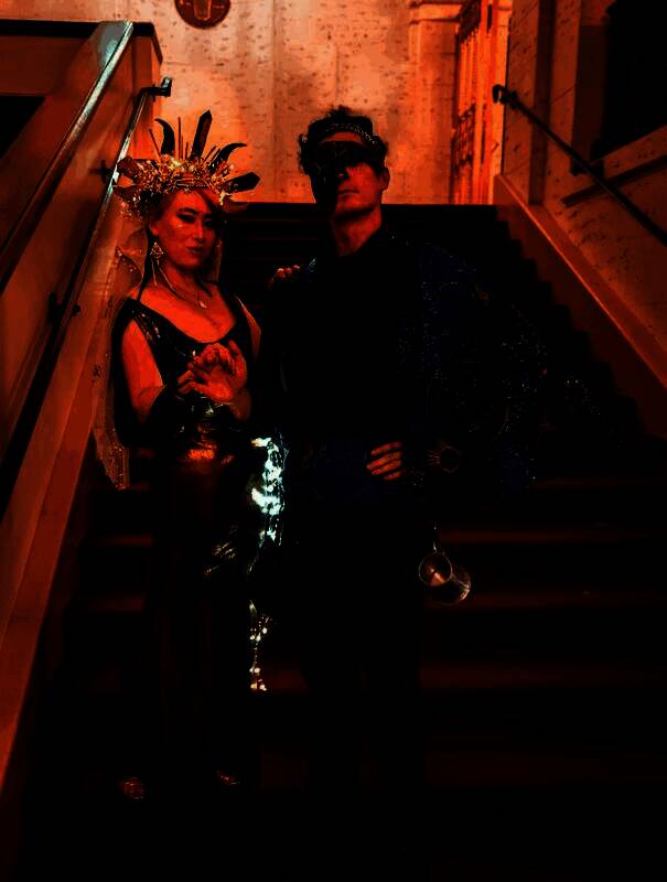 背影照，石井站在楼梯顶端，长发披肩，身后是璀璨灯火与朦胧雾气