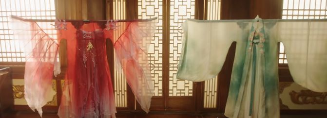 角色站在屏风前试穿不同服饰的画面，左侧为鲜艳红裙，右侧为素雅绿裙，侍女恭敬候立两侧