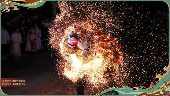 王朝1982在录音棚内佩戴耳机进行歌曲监制的工作照，面前是《虎啸诛仙》的音频波形图，墙上挂着写有‘反叛国风’字样的海报