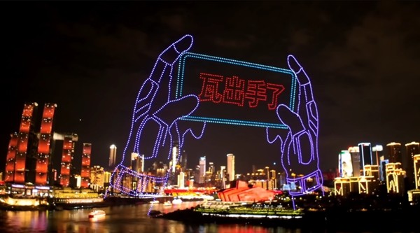 大型展会现场，巨型游戏角色模型矗立中央，粉丝排队合影