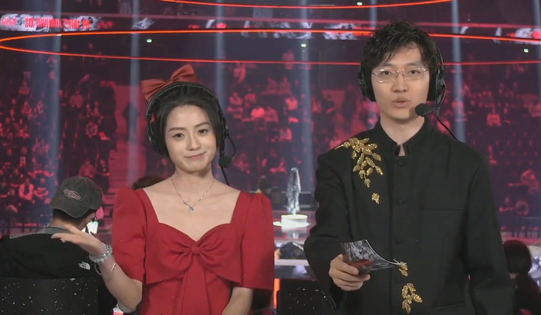 Six Invitational巴黎现场盛况，舞台中央大屏显示醒目的‘CNL’字样，梁嘉升身着黑西装登台宣告，台下观众举旗欢呼，氛围炽热